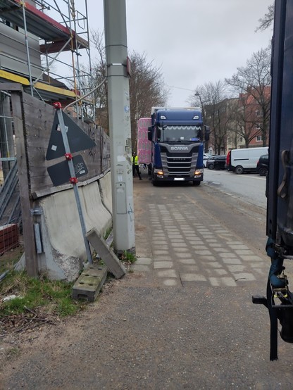 Ein Lastwagen parkt auf einem getrennten Fuß- und Radweg. Dieser wird gerade seitlich entladen, deshalb ist kein Platz für den Fuß- und Radverkehr.