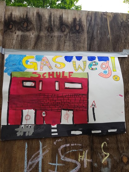Buntes gemaltes Demo Plakat mit der Aufschrift 
Gas weg!

und einem gezeichneten Schulgebäude mit der Aufschrift Schule