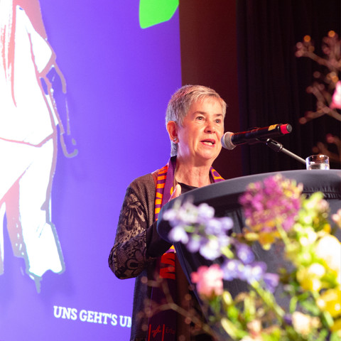 Auf dem Bild ist Dr. Irme Stetter-Karp, die Präsidentin des Zentralkomitees der deutschen Katholiken zu sehen. Sie steht auf der Bühne der Veranstaltung „Parlamentarische Nacht“ beim 103. Katholikentag in Erfurt und spricht vor Publikum.