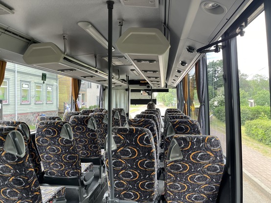View inside the bus. Grey seats orange pattern 