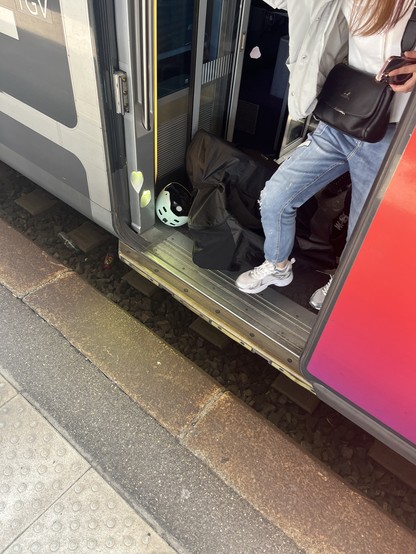 A passenger clambered over a bike in a bag in a TGV vestibule 