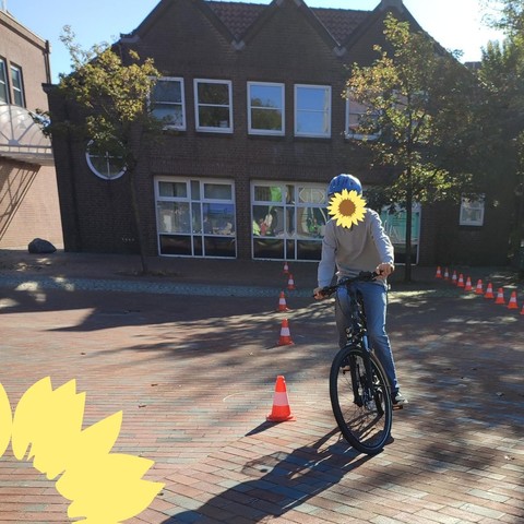 Ein junger Mensch auf einem Fahrrad durchfährt einen Slalomparcour. Das Gesicht ist unkenntlich gemacht.